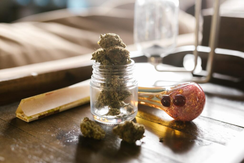 Different colored pipe and a jar of cannabis