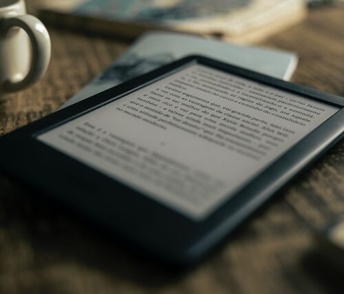 Kindle tablet with page open of book on brown table