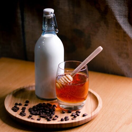 A jug of milk next to a jar of honey, highlighting the ingredients for making cannabis-infused milk and honey.