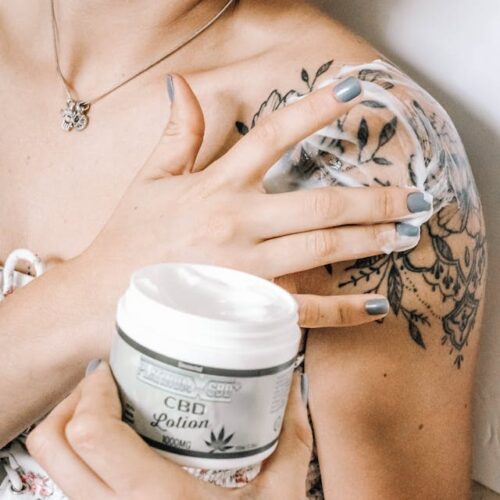 Close-up of a person applying CBD skincare cream on their arm