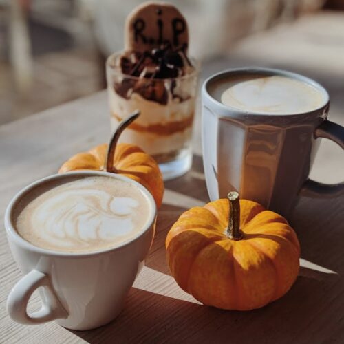 A cozy cannabis-infused pumpkin spice latte topped with whipped cream and a sprinkle of pumpkin spice.